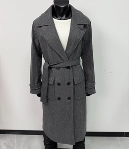 Dettaglio del cappotto lungo in lana grigio scuro con bottoni doppiopetto e cintura