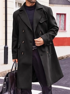Detail of men's black double-breasted wool coat with large lapels and flap pockets