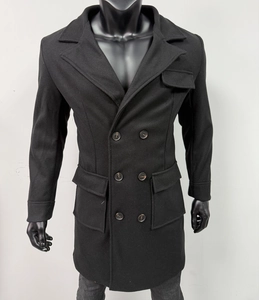 Close-up of double-breasted buttons and flap pocket details on men's black wool overcoat