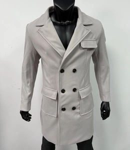 Detail of light gray double-breasted wool coat featuring six buttons and flap pockets