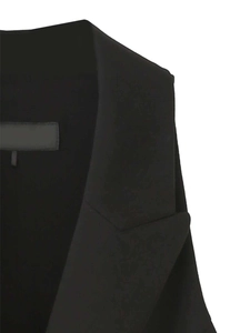 Detailed close-up of the black blazer dress notched lapel and woven fabric texture