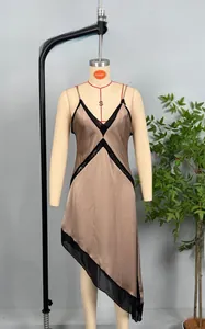 Detail view of champagne satin dress featuring black lace trim and irregular hemline