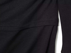 Detailed macro shot of fine black knitted fabric with neat double-needle stitching hem