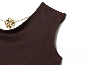 Detail of dark chocolate midi dress featuring a gold rose metal chain neckline