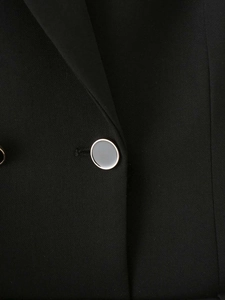 Detail of silver decorative button with grey enamel on black blazer dress fabric