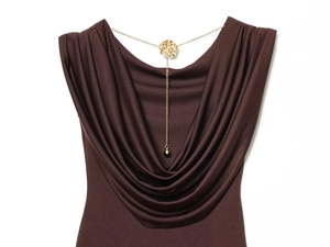 Detail of elegant cowl neck collar with gold rose metallic charm and chain on brown top