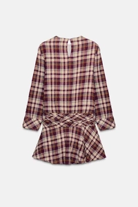 Detail of purple plaid mini dress featuring unique woven cross waist design and textures