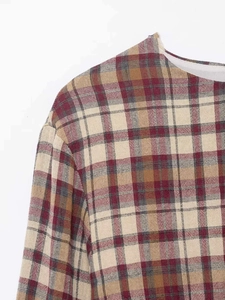 Dettaglio dello scollo e del tessuto a scacchi su un mini abito a quadri alla moda