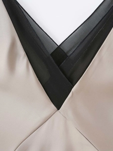 Detail of V-neckline with black lace mesh and champagne satin material patchwork