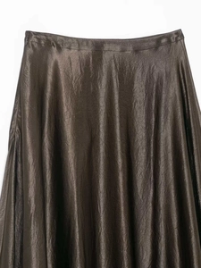 Vue détaillée d'une jupe mi-longue en satin marron foncé avec texture brillante chic