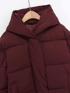 Detail of burgundy quilted puffer coat with high collar hood and matte snap button closure
