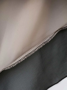 Detail of delicate seam stitching on two-tone brown and black chiffon summer dress fabric