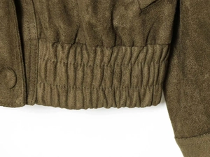 Detail der olivgrünen Wildlederjacke mit elastischem Saum und Druckknopfverschluss