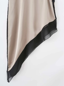 Detail of irregular champagne satin hem with black chiffon and lace patchwork trim
