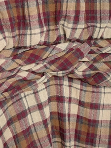 Dettaglio del mini abito a quadri con tessuto scozzese rosso e nodo decorativo