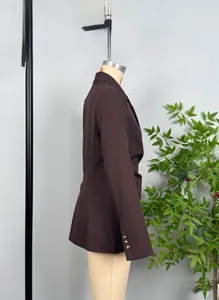 Detail view of golden decorative buttons on a deep brown slim fit women blazer sleeve