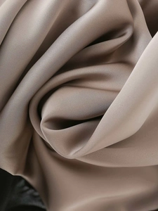 Detail of premium light brown satin fabric with soft drapes and elegant twill texture