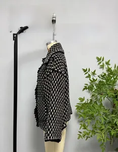 Close-up of black and white plaid tweed cardigan featuring textured woven fabric and pockets