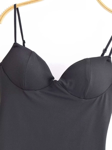 Detail of sweetheart neckline and thin straps on black satin camisole top