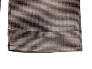 Detail shot of vintage houndstooth wide leg trousers featuring precise double stitching hem
