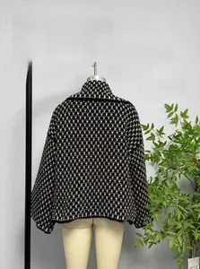 Detail view of black and white plaid knit cardigan sweater on a mannequin