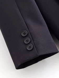 Detailed close-up of suit jacket sleeve featuring three black resin buttons and premium fabric