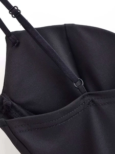 Detail of adjustable elastic straps and neat stitching on a black satin camisole top