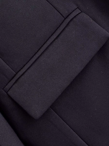 Detailed close-up of pocket flap and fine fabric texture on a loose black blazer jacket