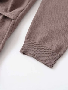 Gros plan détaillé des poignets côtelés et de la texture en maille fine de la robe taupe