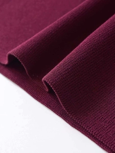 Gros plan sur la texture du tissu en maille côtelée bordeaux d'une robe sans manches