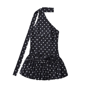Close-up of black polka dot halter mini dress featuring long neck ties and ruffled hemline