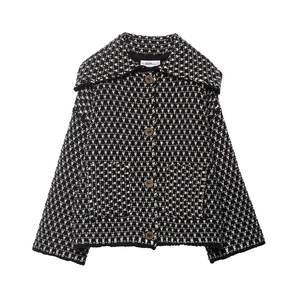 Close-up of lapel and vintage brass buttons on black and white tweed knit jacket