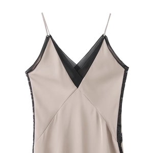 Elegant champagne satin dress with deep V-neck and black lace patchwork on white background