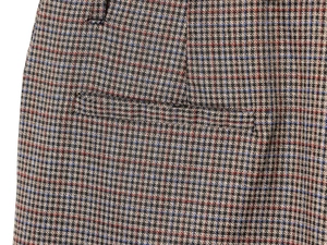 Detailed macro view of vintage houndstooth fabric with subtle red and blue stripes