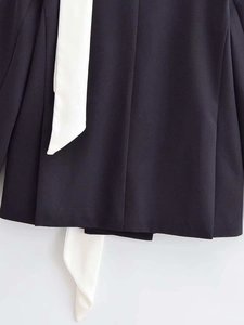 Detail view of woven navy blue blazer fabric with white contrast lacing detail