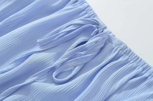 Detail of light blue pleated fabric with elastic smocked waist and drawstring detail