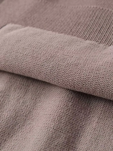 Détail macro du tissu en maille rose avec bords côtelés et texture de qualité