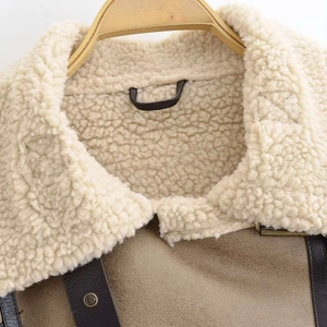 Close-up of winter jacket featuring sherpa fleece collar and brown suede texture