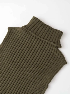 Dettaglio del top in maglia verde oliva con collo alto e texture a coste fini