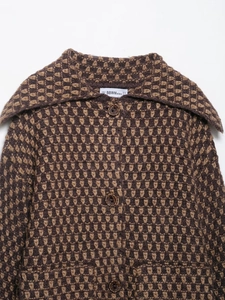 Detail of knitted cardigan with wave pattern, large lapel, and faux wood buttons