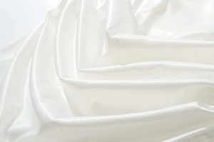 Vue détaillée du tissu en satin blanc avec des plis élégants et une texture soyeuse