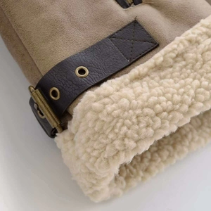 Detailed close-up of khaki suede jacket with white faux shearling lining and leather straps