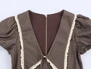 Detailed view of vintage plaid dress featuring lace trim V-neck and invisible back zipper