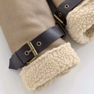 Detailed close-up of khaki suede jacket cuffs with shearling lining and buckle straps