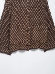 Detail of vintage knit cardigan showing heart texture pattern and brown buttons
