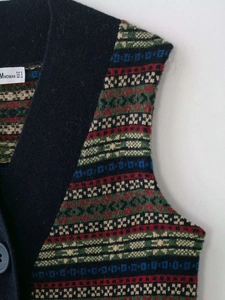 Detail shot of the Fair Isle geometric knit pattern and Mwoman brand label on neck