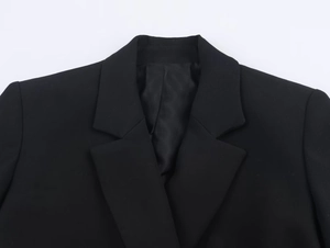 Close-up of a black blazer featuring a classic notch lapel and high-quality stitching detail