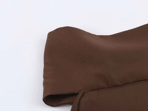 Macro detail of dark brown twill fabric texture and stitching on the halter neck top