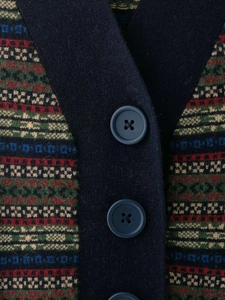 Close-up of Fair Isle jacquard knit vest featuring deep blue V-neck and large matte buttons