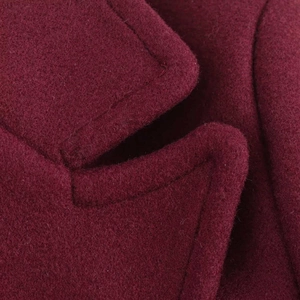 Macro shot of premium burgundy wool coat fabric showing fine texture and stitching